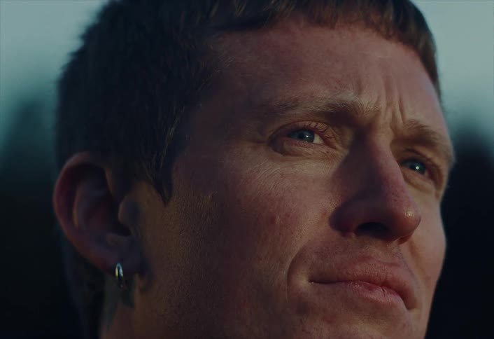 Close-up of a thoughtful man's face illuminated by the warm light of sunset