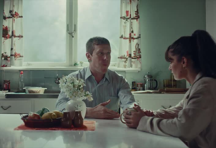 Man and woman engaged in a deep and serious conversation over coffee at their kitchen table