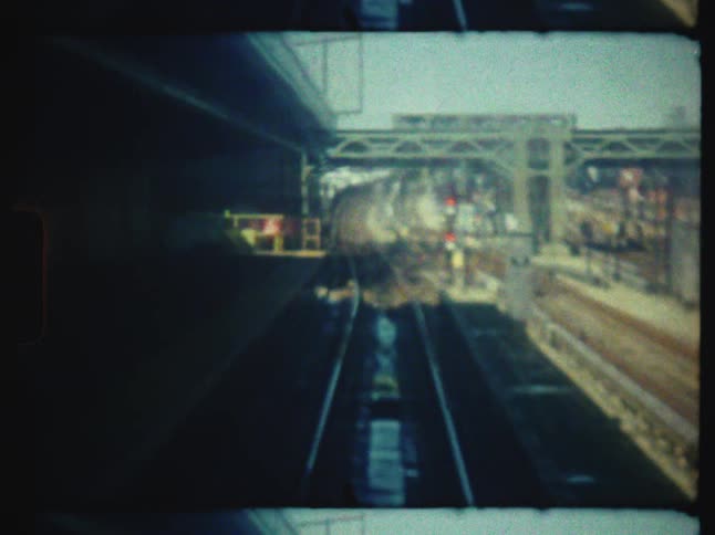 A vintage, out-of-focus point-of-view shot from a moving train looking down the railroad tracks