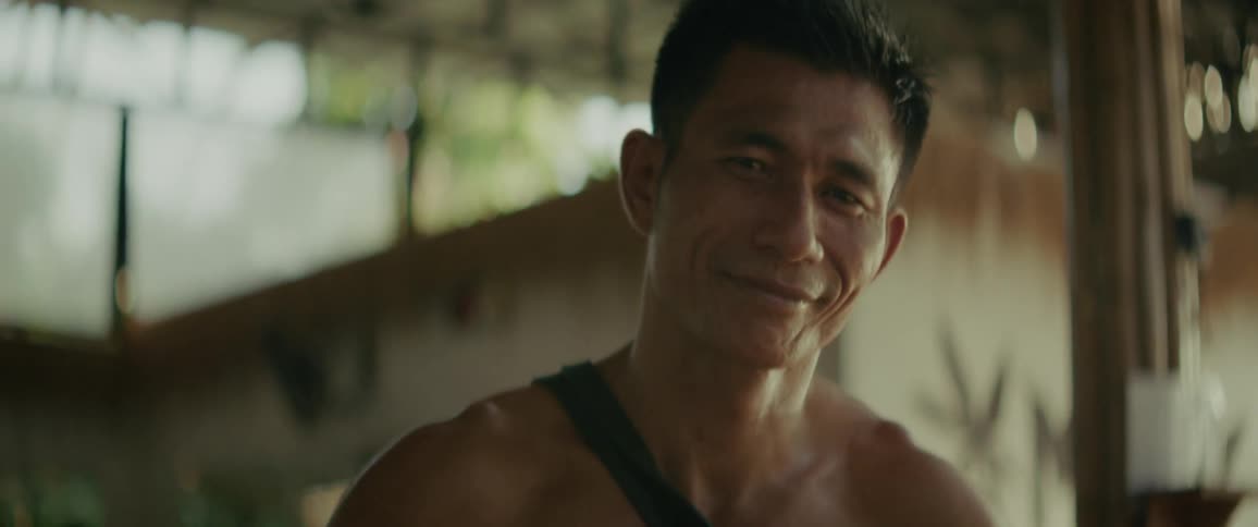 Slow motion close-up portrait of a happy shirtless man smiling warmly at the camera and giving two thumbs up