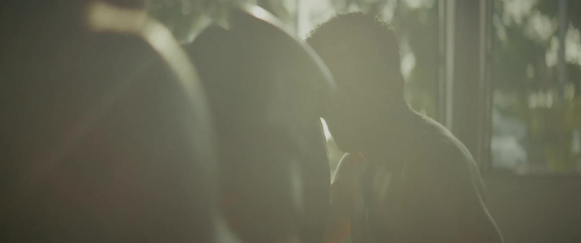 Cinematic close up of two men boxing in a hazy, sun-drenched gym