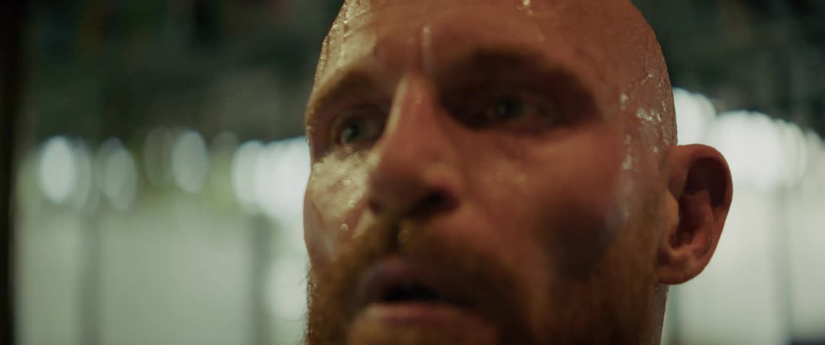 An extreme close-up of a sweaty, exhausted athlete's face as it shifts from intense focus to a triumphant and relieved smile