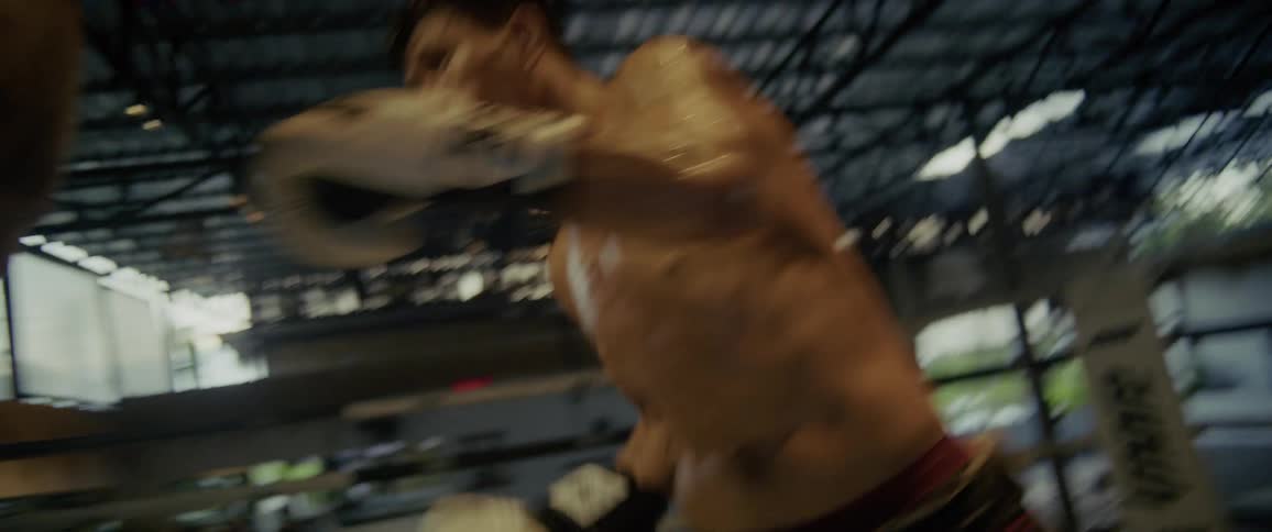 Dynamic slow-motion footage captures an intense Muay Thai fight, culminating in a powerful knockout kick