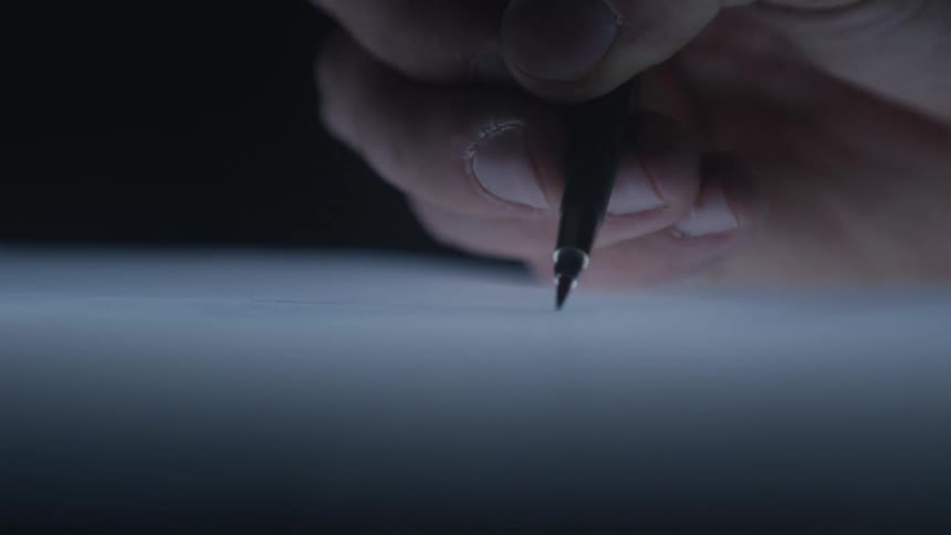 A dramatic close-up of a hand drawing a fine line with a mechanical pencil on a piece of paper