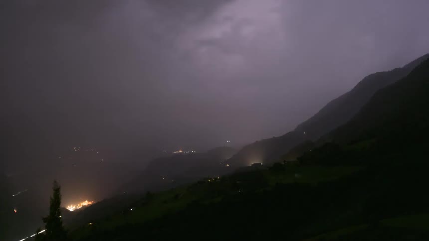 Time-lapse of a dramatic nighttime thunderstorm with frequent lightning flashes over a mountain valley