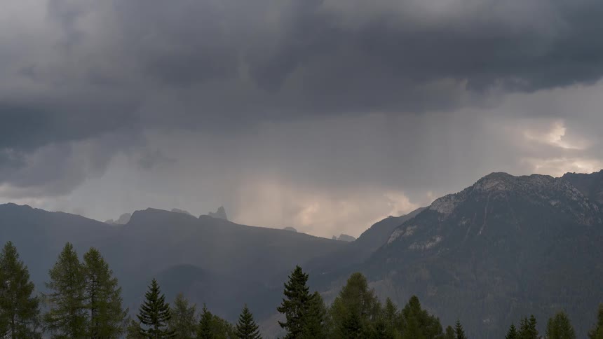 Dark storm clouds and rain sweep across the mountains in this dramatic timelapse