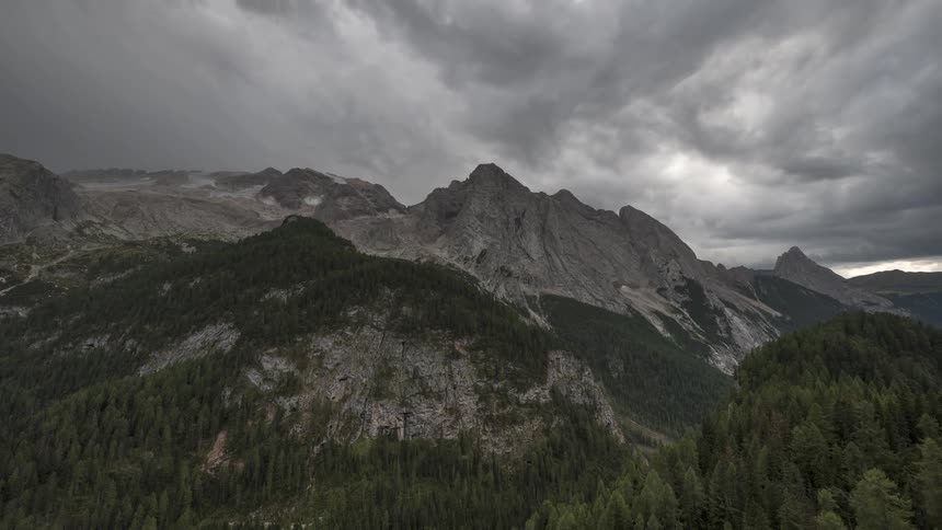 Dramatic time-lapse of dark storm clouds moving across the Marmolada mountain range in the Italian Dolomites