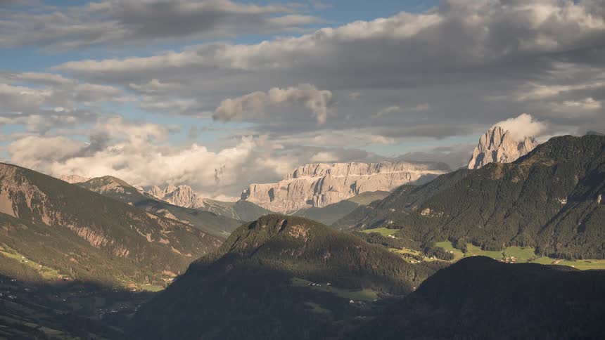 A stunning timelapse shows clouds rolling over a vast mountain range, with shadows sweeping across the green valleys below