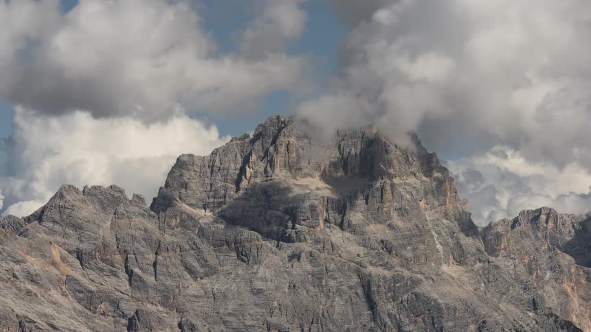 A time-lapse of clouds moving over the rugged peak of a mountain in the Dolomites