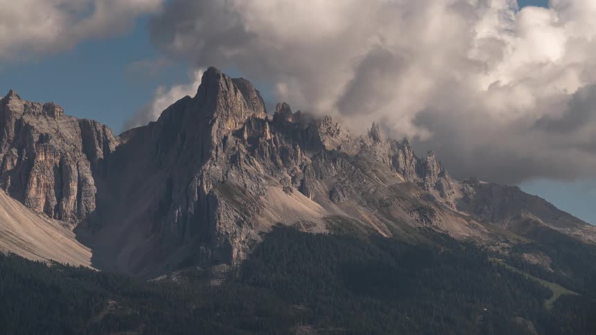 A dramatic time-lapse of clouds rolling over the jagged peaks of a mountain range