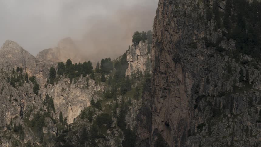 Thick fog slowly clears away to reveal the rugged and majestic peaks of a mountain range
