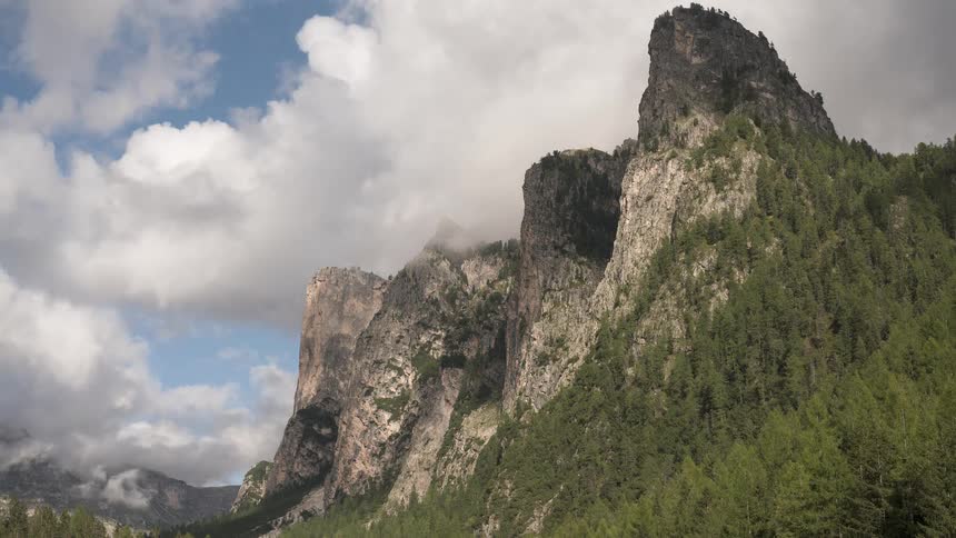 Dramatic clouds swirl and drift across majestic mountain peaks in a beautiful timelapse