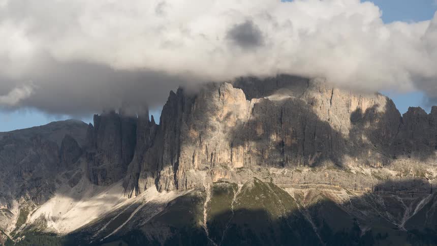 A stunning timelapse shows clouds and shadows moving across a rugged and majestic mountain range