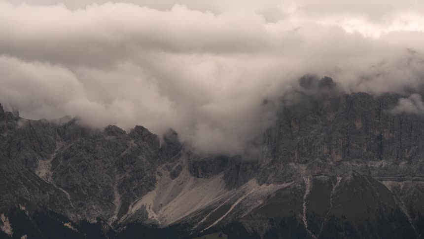 A dramatic time-lapse of swirling storm clouds engulfing a rugged mountain range
