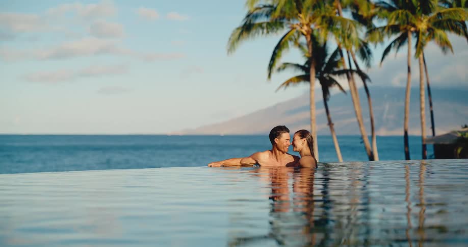 Romantic couple relaxing together in a beautiful infinity pool at a luxury resort, enjoying their tropical vacation