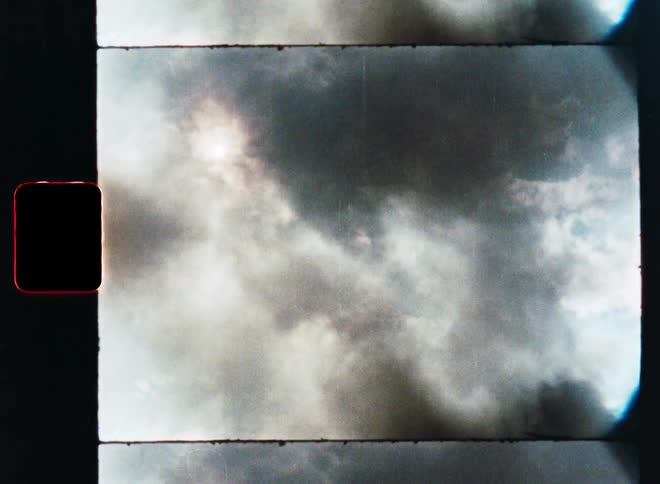 Vintage film strip shows ominous black smoke clouds filling the sky and obscuring the sun