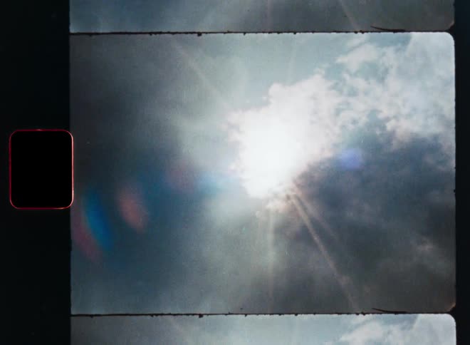 Vintage film footage shows a large plume of dark smoke billowing into the sky as the sun shines through the haze