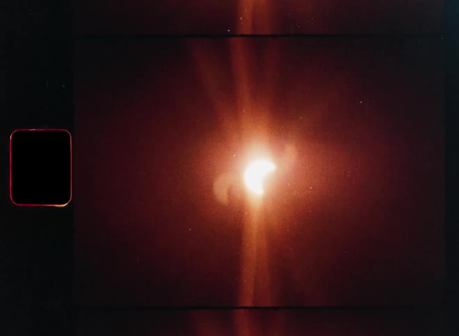 Retro 8mm film of a partial solar eclipse with warm lens flares and vintage film grain