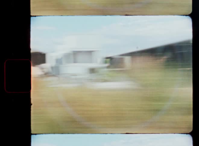 Vintage 8mm film captures a blurry, fast-paced view of the countryside from a moving train window