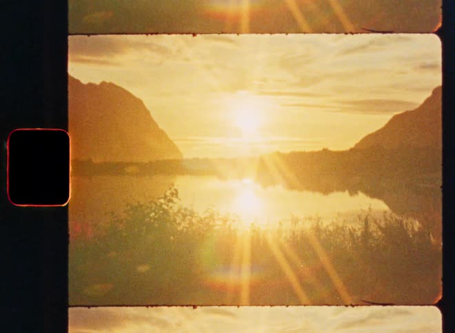 A dreamy, vintage film-style animation shows a golden sunset reflecting over a tranquil mountain lake
