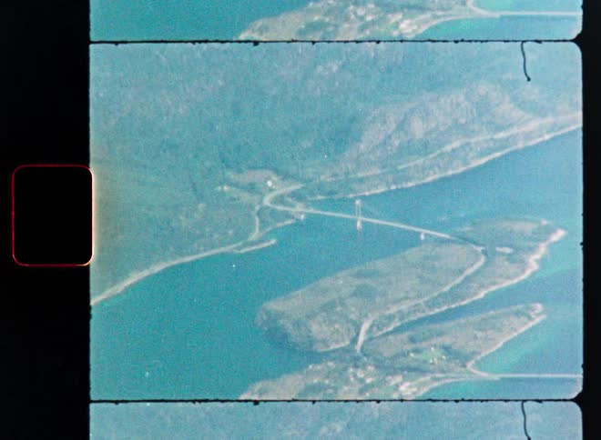 Vintage 8mm film shows an aerial view of islands and a bridge over beautiful turquoise water