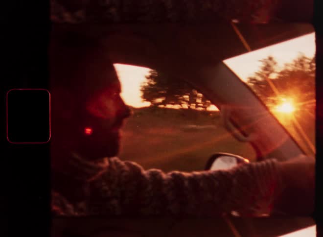 Vintage Super 8 film captures a man driving through the countryside during a beautiful golden hour sunset