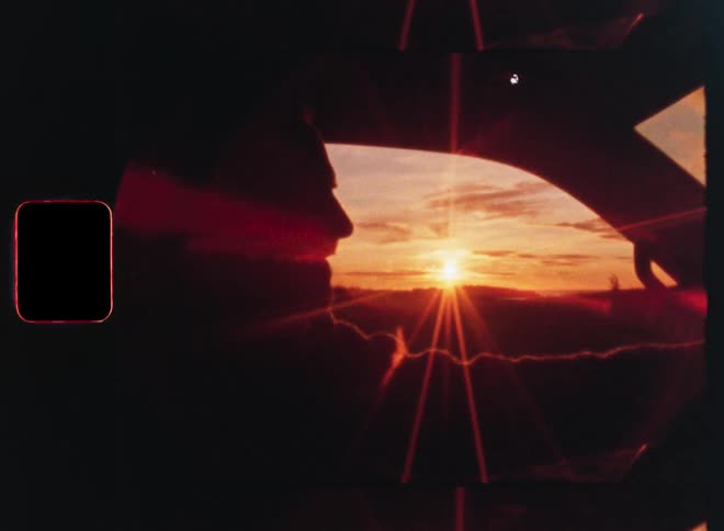 A silhouetted person drives towards the setting sun in a vintage, artistic shot with kaleidoscopic lens effects