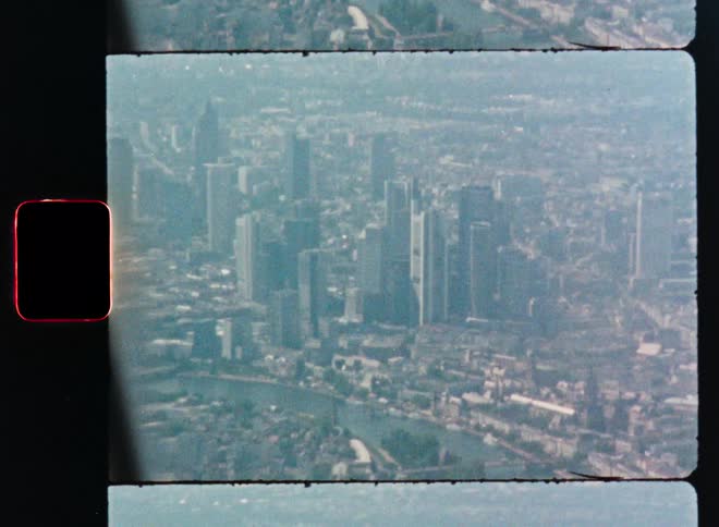 Vintage 8mm film captures an aerial view of the Frankfurt, Germany cityscape from an airplane window