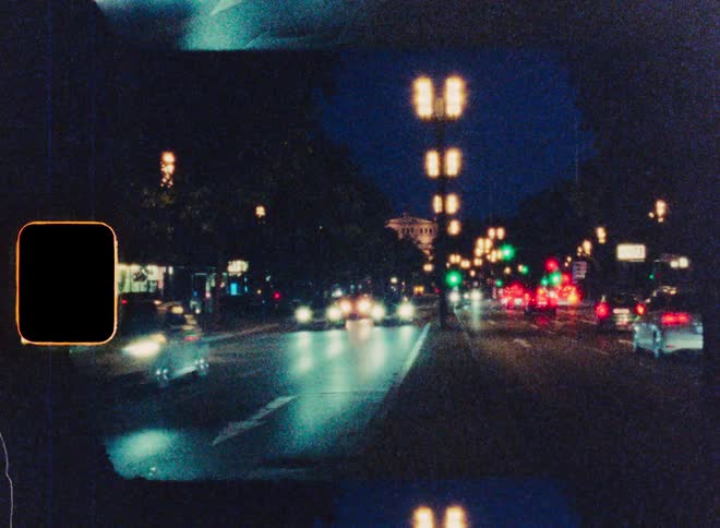 Dreamlike timelapse footage on vintage 8mm film captures the blur of traffic on a city street at night