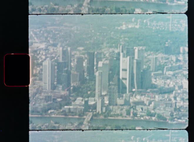 Aerial view of the Frankfurt city skyline with its prominent skyscrapers, captured on a grainy vintage film strip