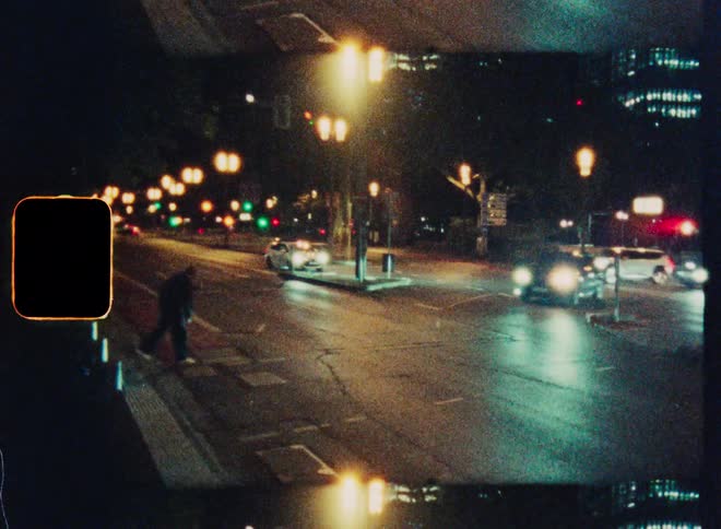 A blurry, high-angle view of night traffic on a city street, captured on vintage-style film