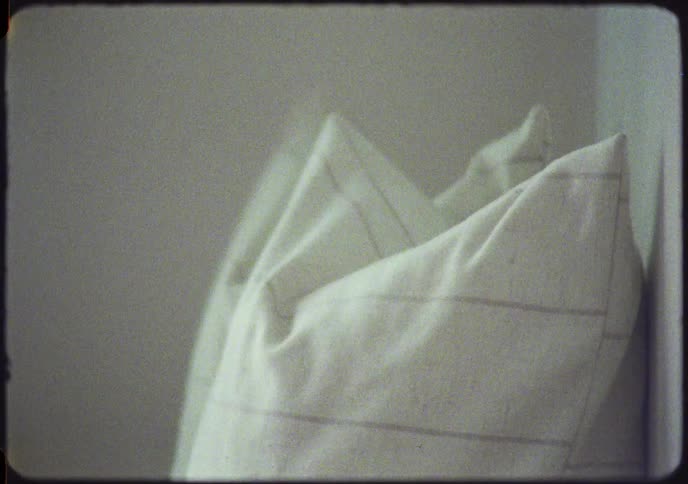 A woman's hand rummages inside a black leather handbag before grabbing it by the strap and taking it, shot in a vintage Super 8 film style