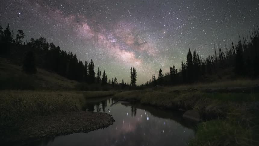 A stunning dusk-to-night time-lapse reveals the Milky Way galaxy and airglow rising over a tranquil river in a remote forest valley