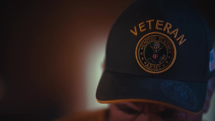 Close-up cinematic shot of an elderly US Army veteran's hat