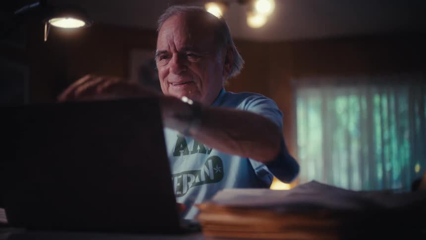 An elderly Army veteran smiles and gets emotional while using his laptop, then closes it with a look of peaceful satisfaction