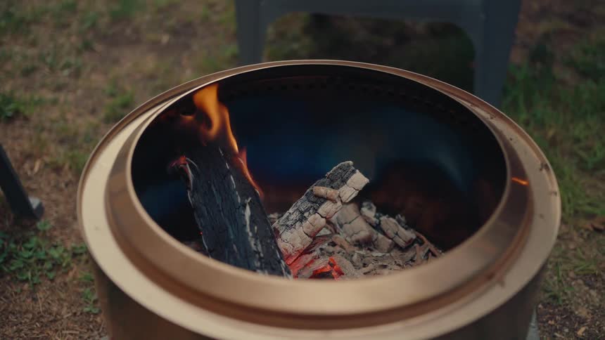A close-up slow-motion shot of firewood burning in a modern outdoor fire pit