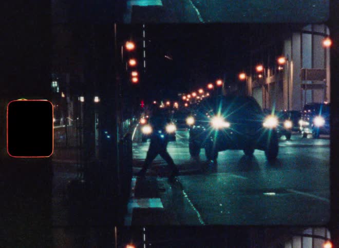 A stylized, grainy film strip shows a person crossing a busy city street at night