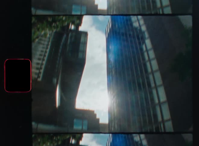 Experimental film strip reveals a low-angle tilt from modern skyscrapers to a sun-drenched city street
