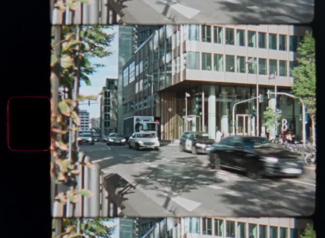 Vintage split-screen film captures a busy city intersection with cars and pedestrians on a sunny day