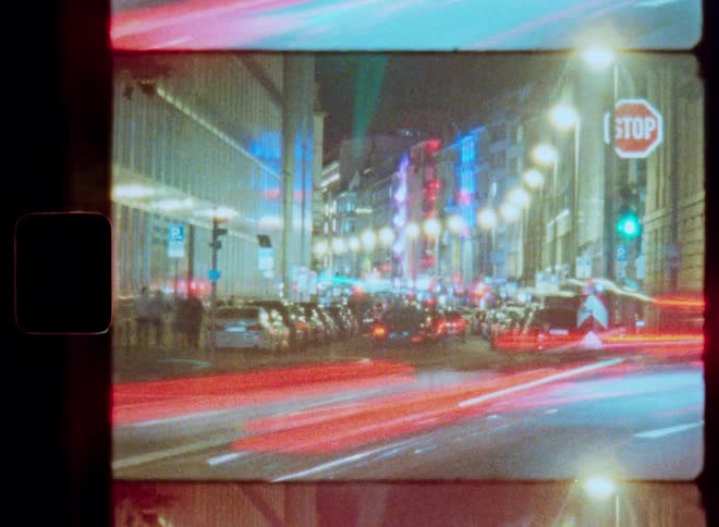 A vintage film time-lapse captures the vibrant energy of a city at night with colorful light trails from passing traffic