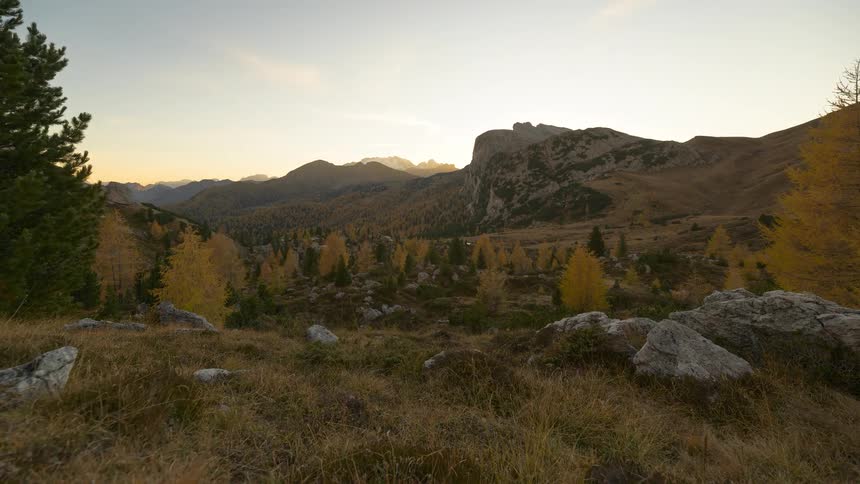A stunning day-to-night timelapse of a gorgeous mountain valley with golden yellow trees as the sun sets behind the peaks
