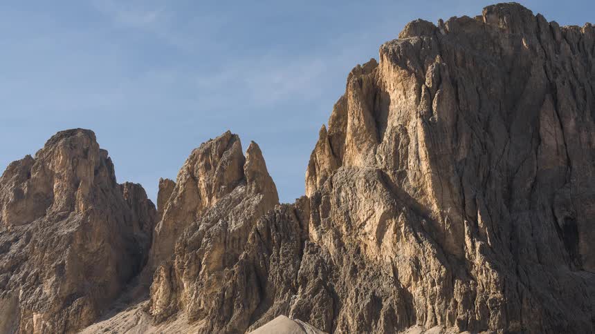 A majestic timelapse of rugged, sun-drenched mountain peaks under a vast blue sky