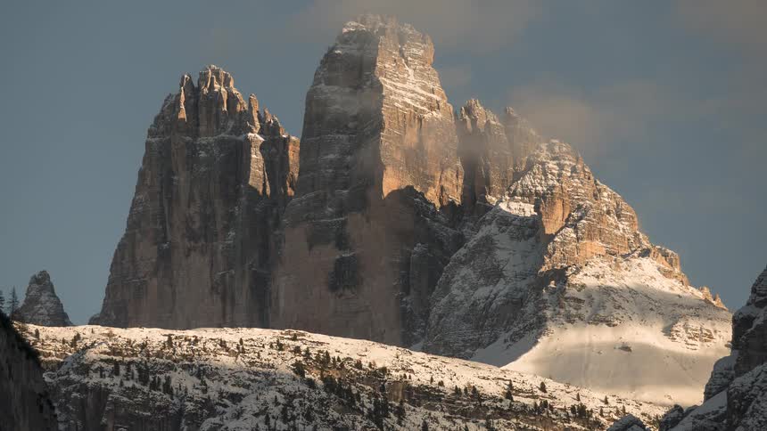 Stunning timelapse of clouds and shadows moving across the snowy peaks of Tre Cime di Lavaredo in the Dolomites
