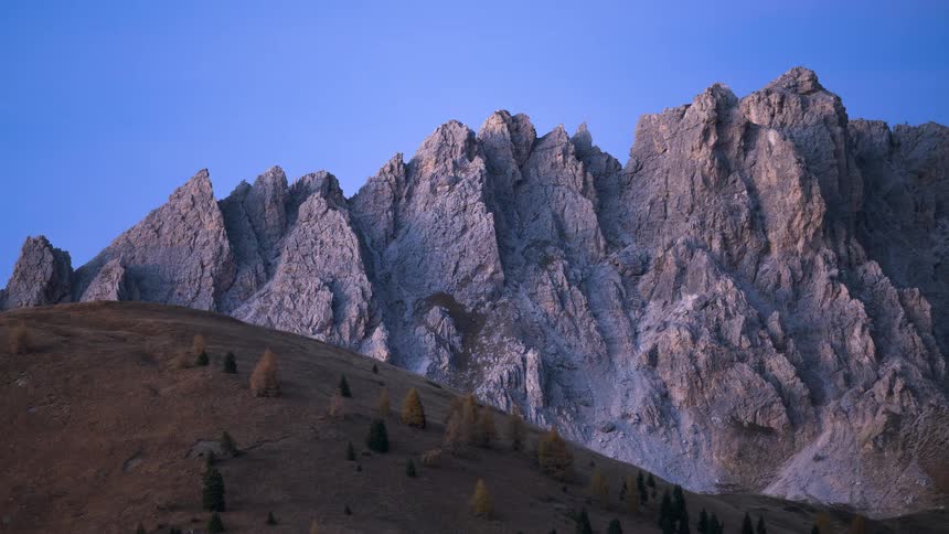 A breathtaking day-to-night time-lapse of the jagged peaks of the Dolomites as the evening sky transitions to a starry night