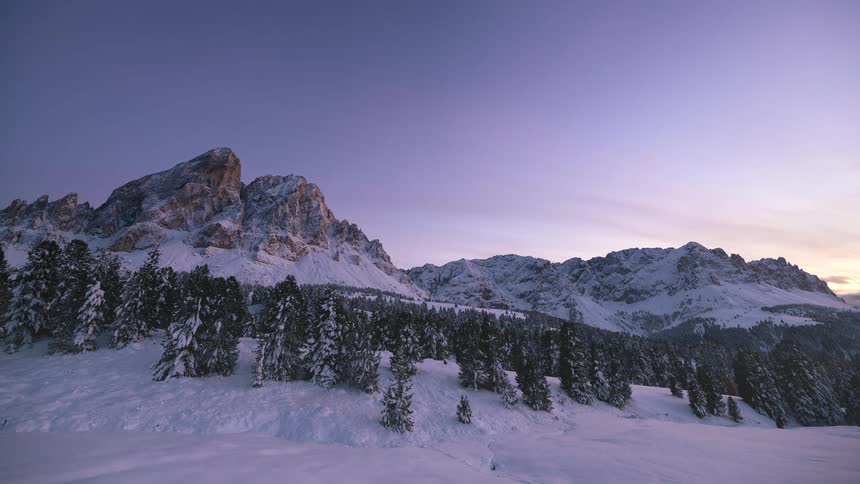 A beautiful timelapse of the last light of day fading over a stunning snow-covered mountain landscape