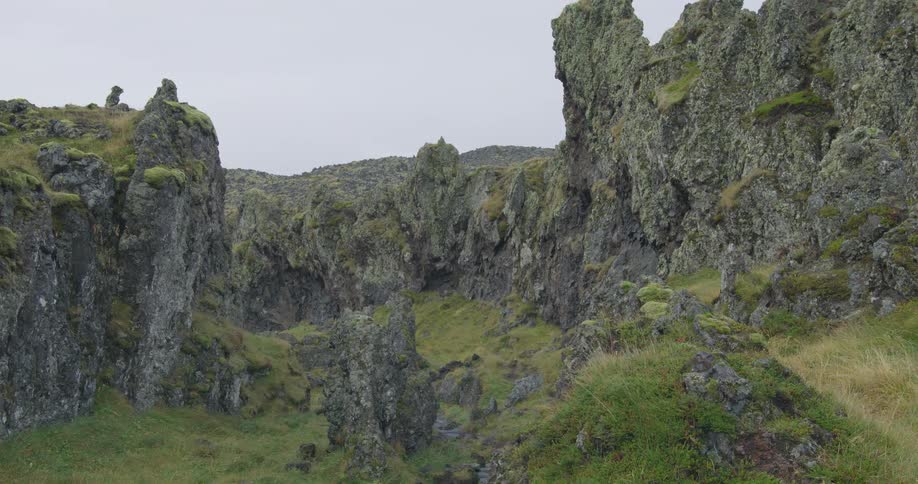 A desolate and rugged canyon of moss-covered volcanic rock in the Icelandic highlands