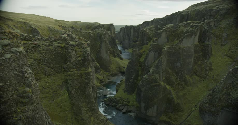 A slow rack focus reveals the stunning and dramatic green mossy cliffs of Fjaðrárgljúfur canyon in Iceland