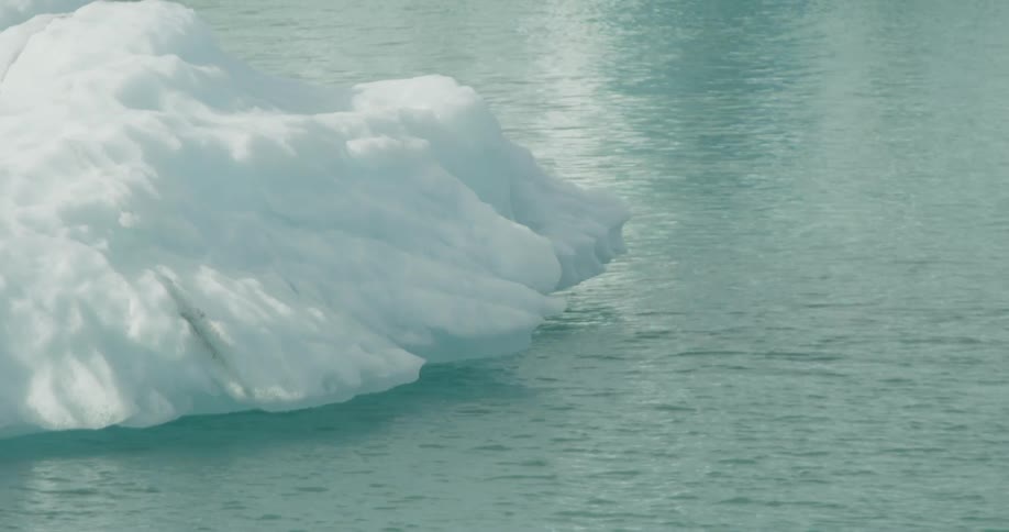 Serene close-up of an iceberg's edge in the gently rippling glacial water