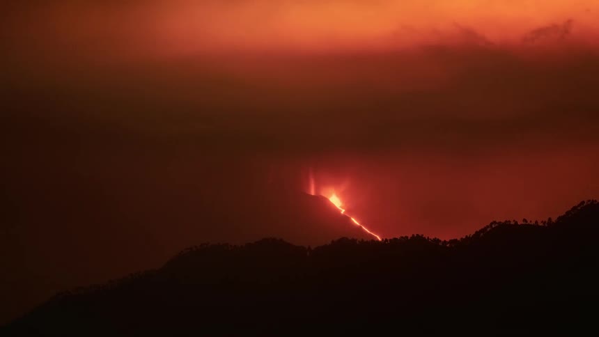 Time-lapse of a dramatic nighttime volcanic eruption with glowing lava flows and fiery red smoke plumes billowing into the sky