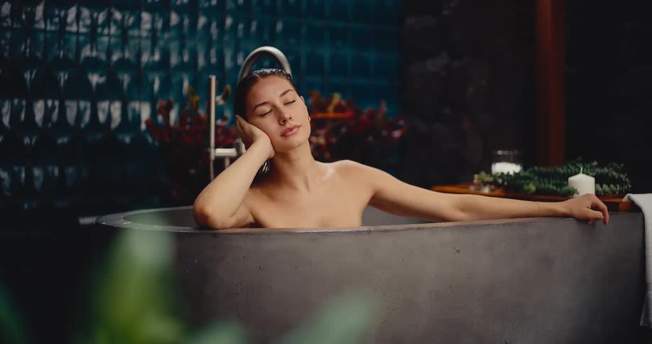 Attractive woman finds serenity as she relaxes in a modern, luxurious bathtub at a day spa